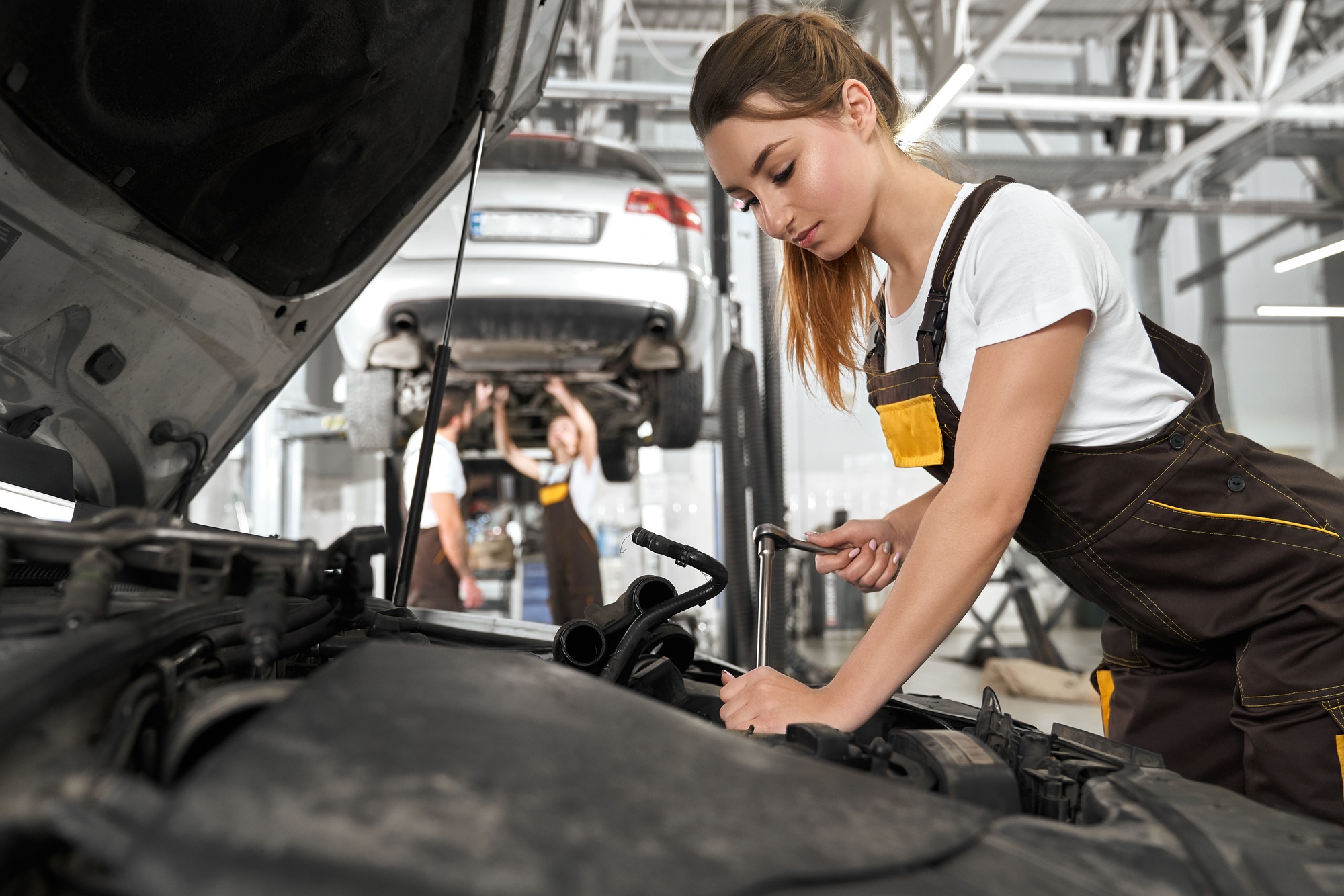Pretty girl working as mechanic in autoservice